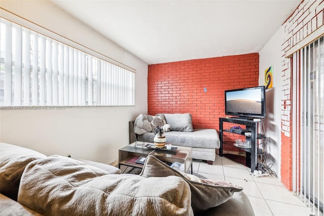 living room featuring light tile patterned floors and brick wall