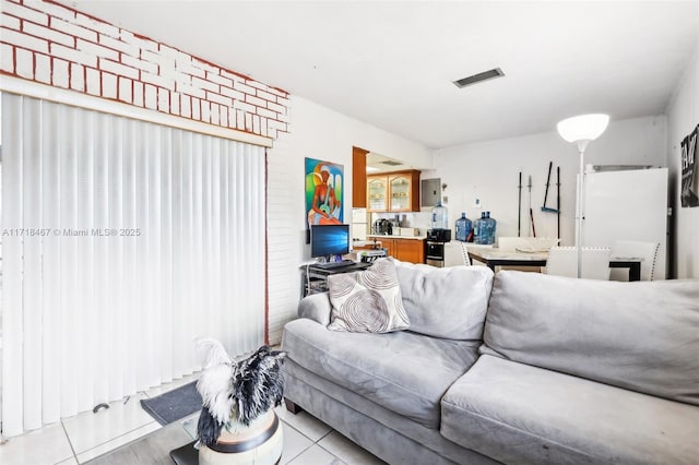 living room with electric panel and light tile patterned flooring