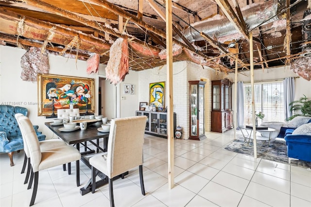 tiled dining area featuring brick wall