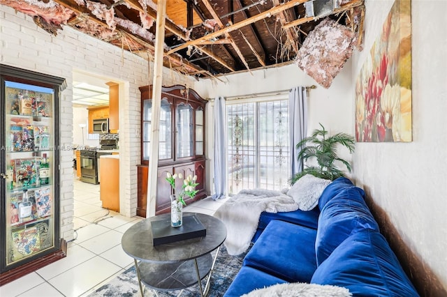 living room featuring light tile patterned floors and brick wall