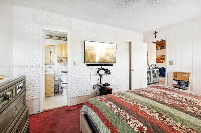 bedroom featuring ensuite bathroom and a textured ceiling