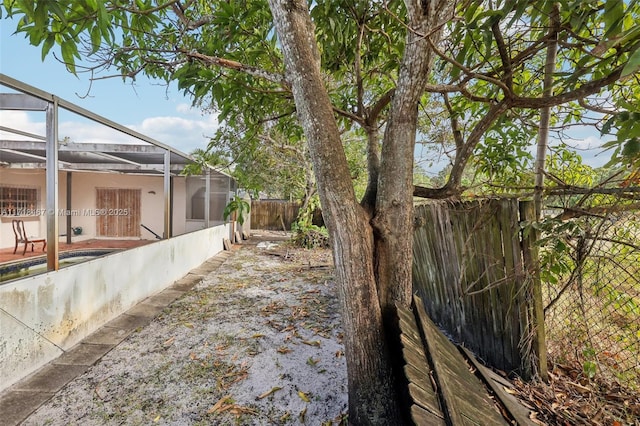 view of yard featuring glass enclosure and a pool