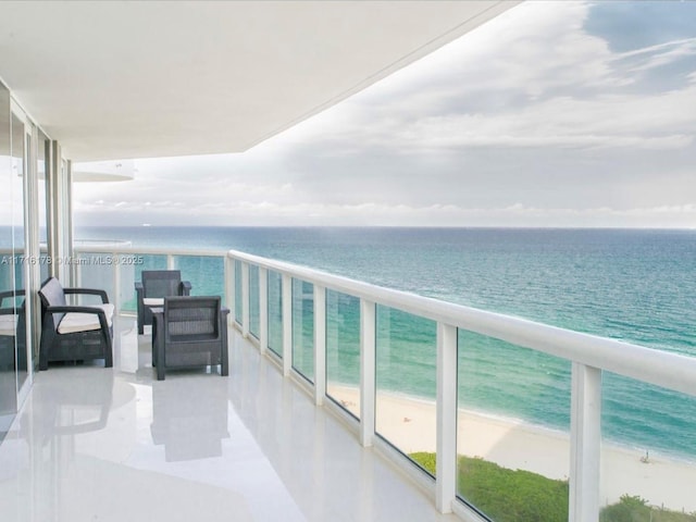 balcony with a water view and a view of the beach