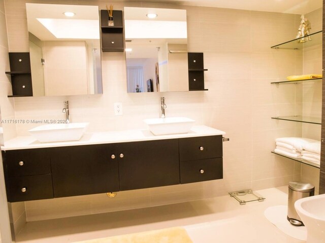 bathroom with vanity, tile walls, and decorative backsplash