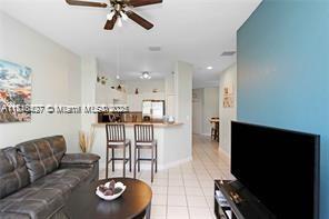 living room with ceiling fan and light tile patterned flooring