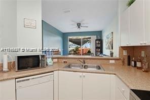 kitchen featuring white dishwasher, ceiling fan, white cabinetry, and sink