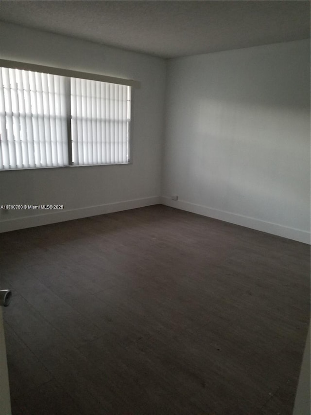 unfurnished room featuring dark hardwood / wood-style flooring