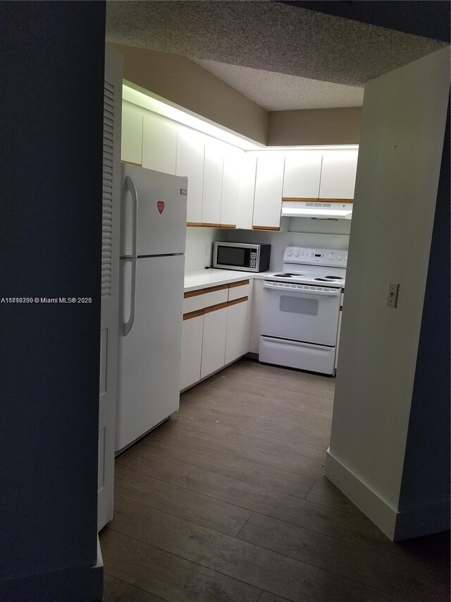 kitchen with a textured ceiling, white appliances, white cabinetry, and light hardwood / wood-style floors