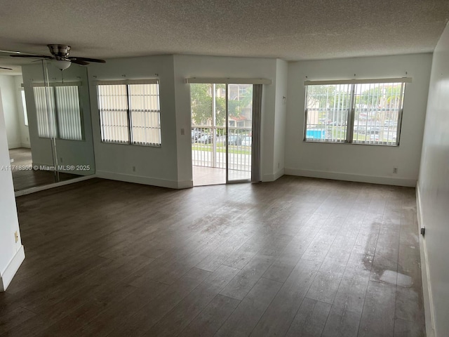 empty room with ceiling fan, a textured ceiling, and dark hardwood / wood-style flooring