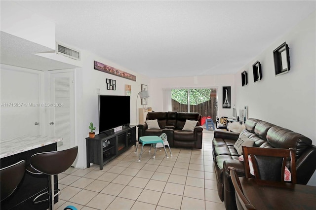 tiled living room featuring a textured ceiling