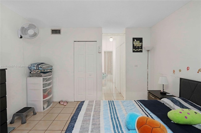 bedroom with light tile patterned flooring and a closet