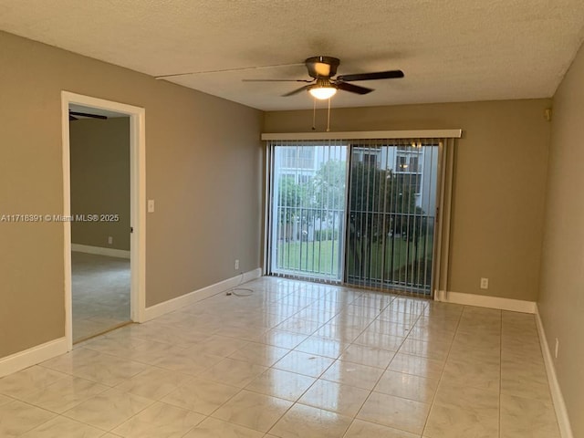 tiled empty room featuring ceiling fan and a textured ceiling