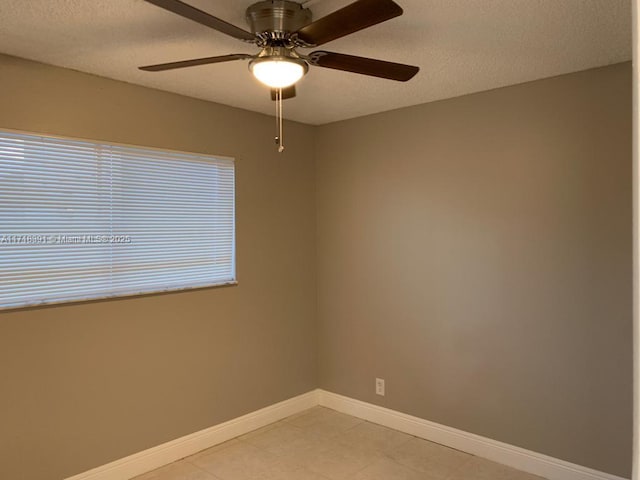 unfurnished room with ceiling fan and a textured ceiling