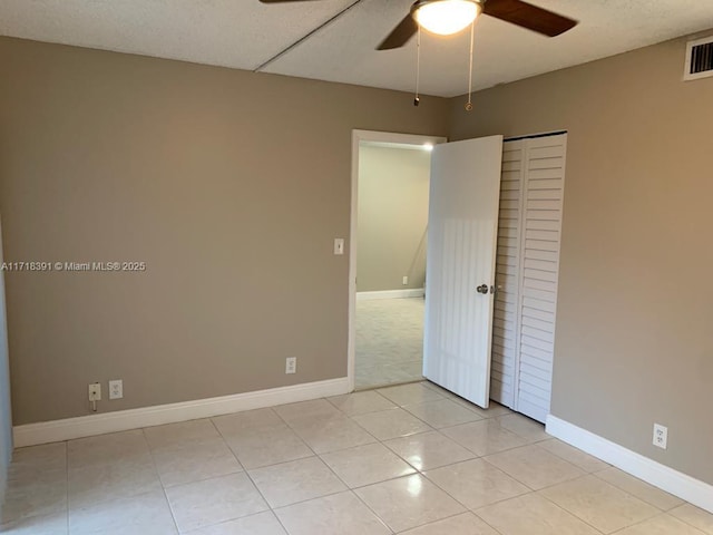 tiled spare room featuring ceiling fan