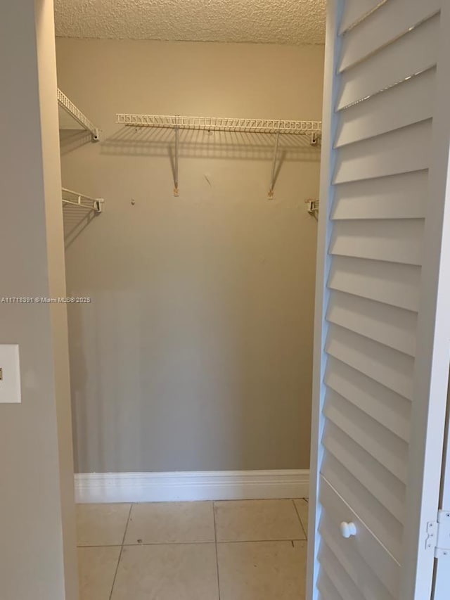 walk in closet with light tile patterned floors