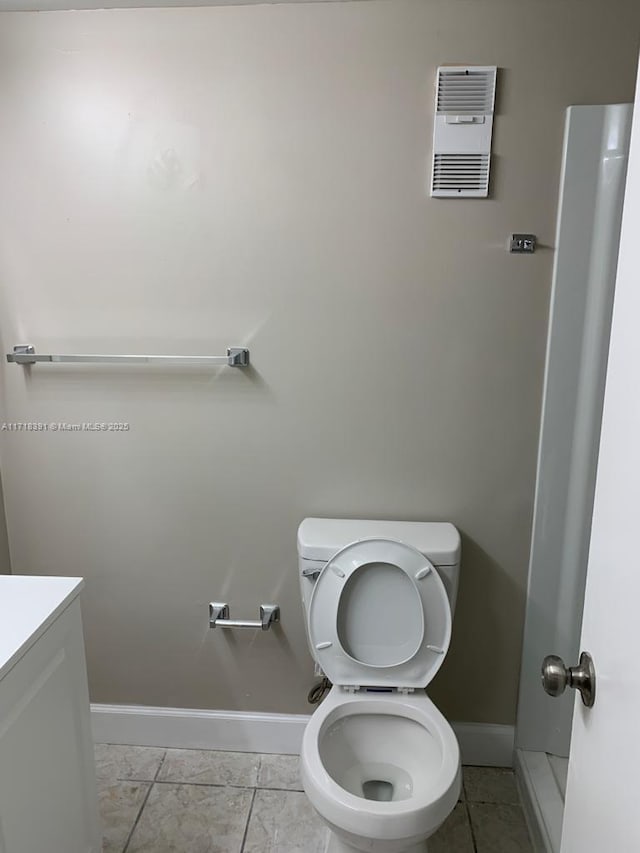 bathroom featuring tile patterned flooring, vanity, and toilet