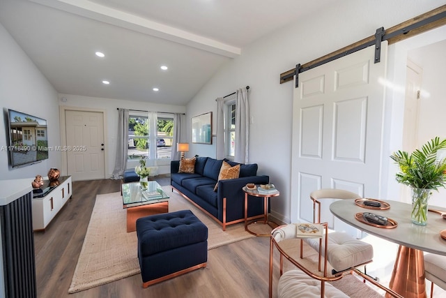 living room featuring vaulted ceiling with beams, dark hardwood / wood-style floors, and a barn door