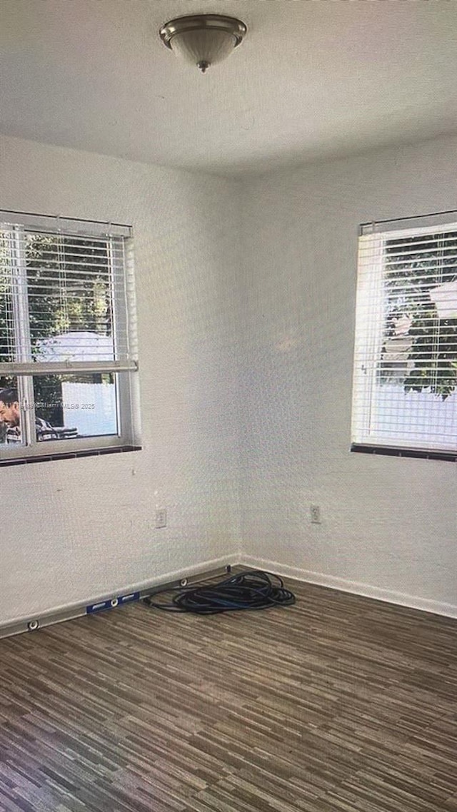 empty room with dark hardwood / wood-style flooring