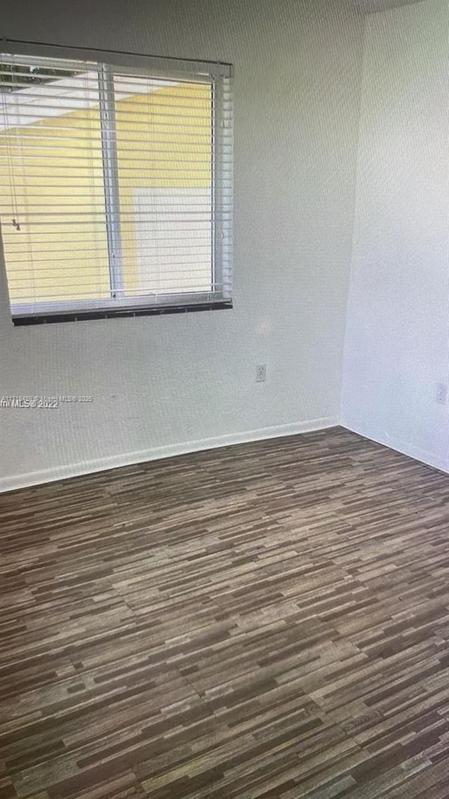 spare room with dark hardwood / wood-style flooring