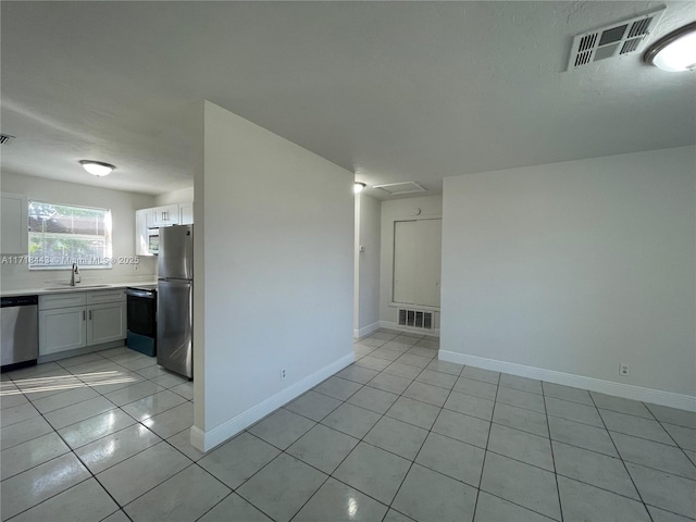 empty room featuring light tile patterned flooring and sink