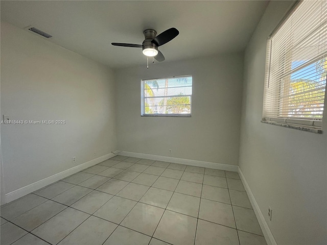 tiled spare room with ceiling fan