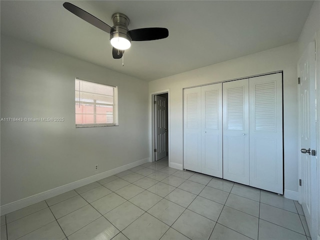 unfurnished bedroom with ceiling fan, light tile patterned floors, and a closet