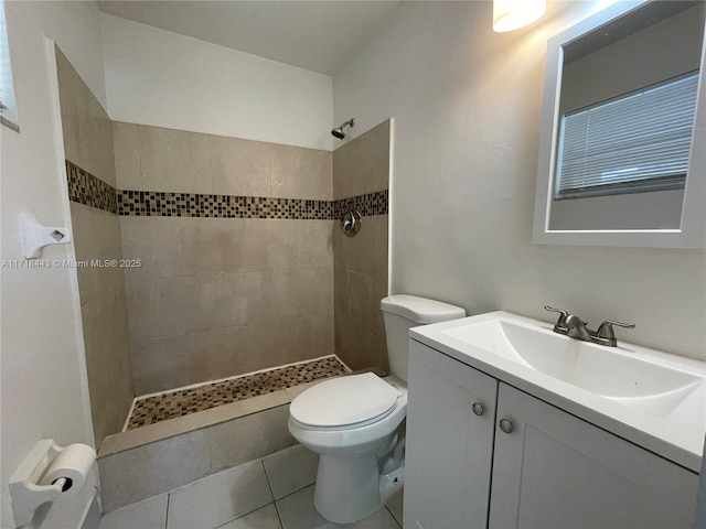 bathroom featuring tile patterned flooring, vanity, tiled shower, and toilet