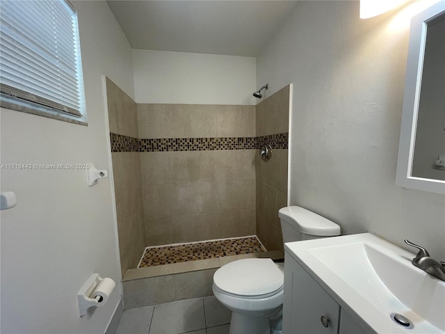 bathroom featuring toilet, vanity, tiled shower, and tile patterned floors