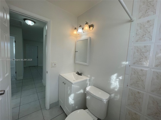 bathroom with toilet, vanity, and tile patterned floors