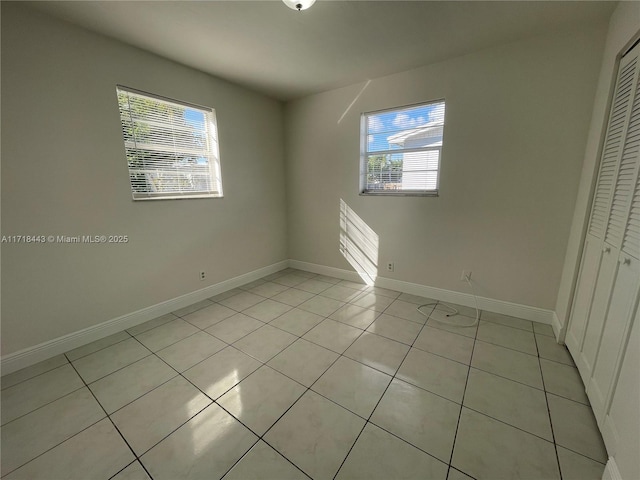 unfurnished bedroom with light tile patterned floors and a closet