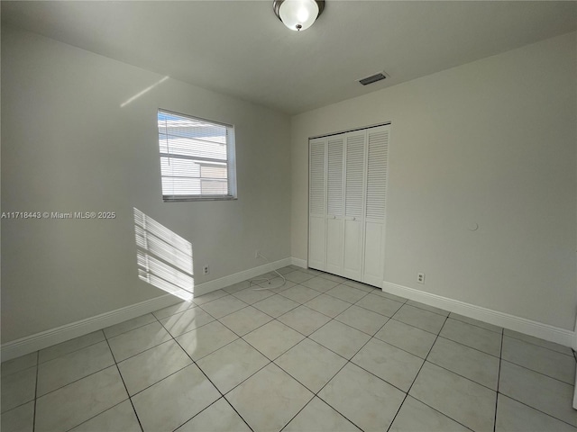 unfurnished bedroom with light tile patterned floors and a closet