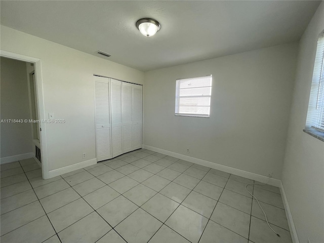 unfurnished bedroom featuring a closet and light tile patterned floors