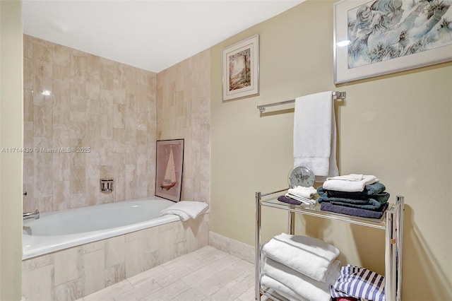 bathroom with tile patterned flooring and tiled tub