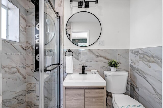 bathroom with vanity, a shower with shower door, and tile walls