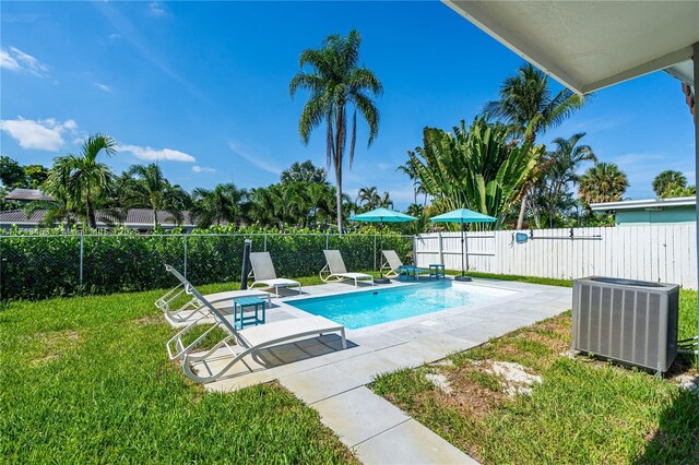 view of pool with a yard, a patio, and cooling unit