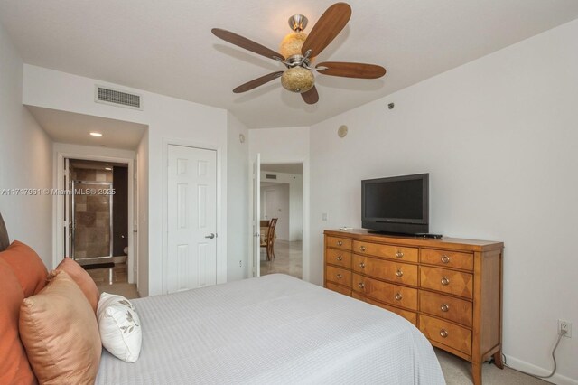 bedroom with light carpet, connected bathroom, and ceiling fan