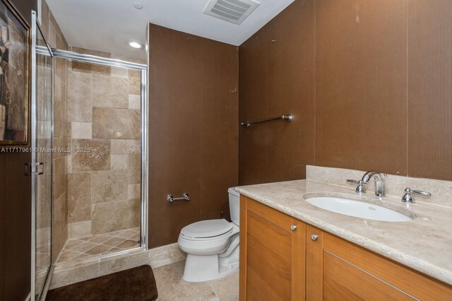 bathroom with tile patterned floors, vanity, toilet, and walk in shower