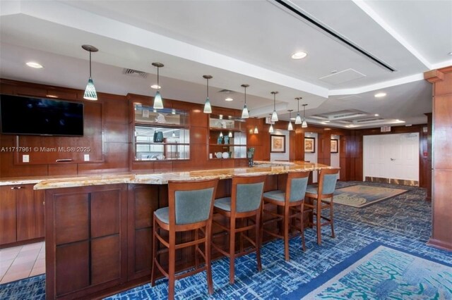 bar featuring pendant lighting, dark tile patterned floors, and light stone countertops