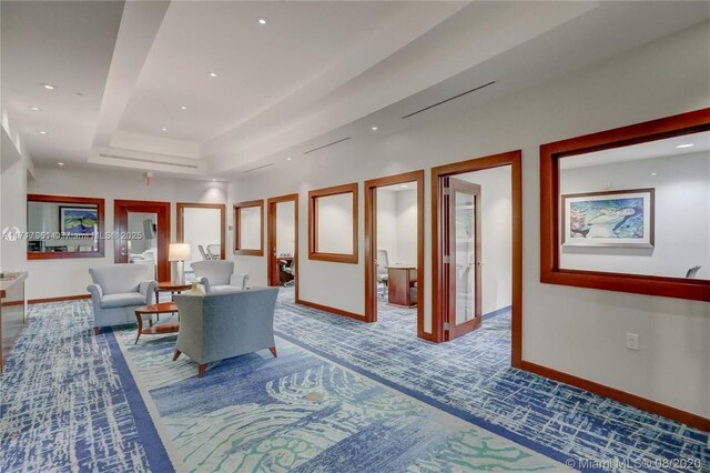 interior space with carpet flooring and a tray ceiling