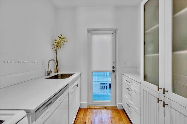 interior space featuring sink, white dishwasher, white cabinetry, and light hardwood / wood-style floors