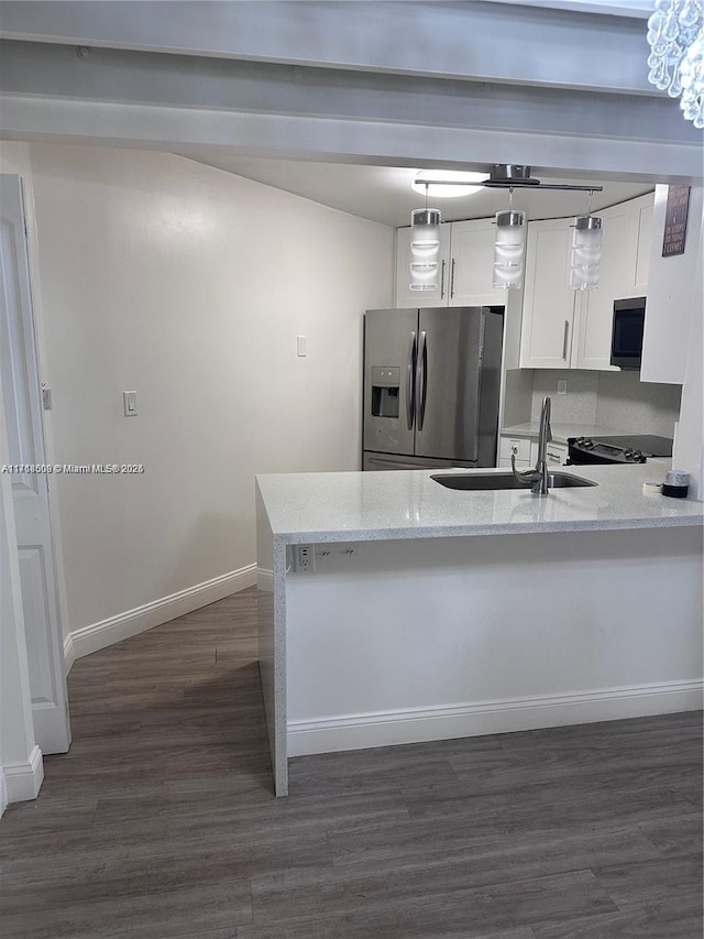 kitchen featuring dark hardwood / wood-style flooring, light stone counters, sink, stainless steel fridge with ice dispenser, and white cabinetry