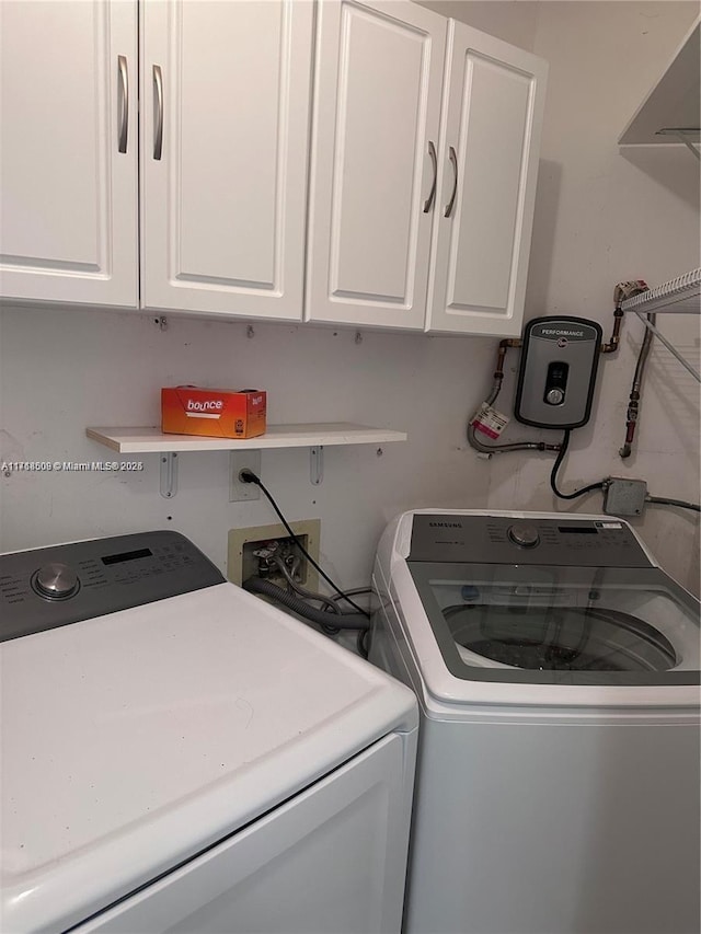 washroom with washing machine and dryer and cabinets