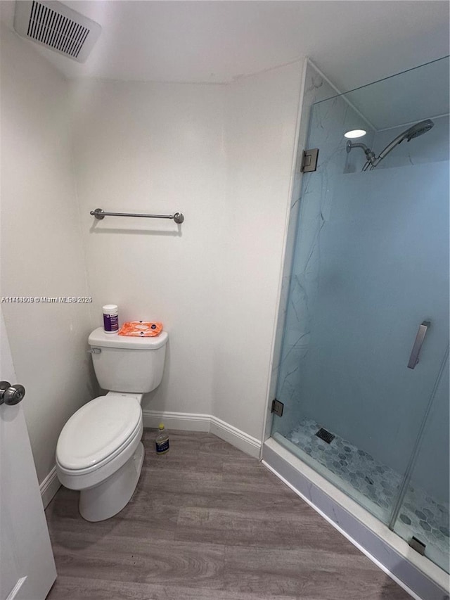 bathroom featuring hardwood / wood-style floors, toilet, and walk in shower