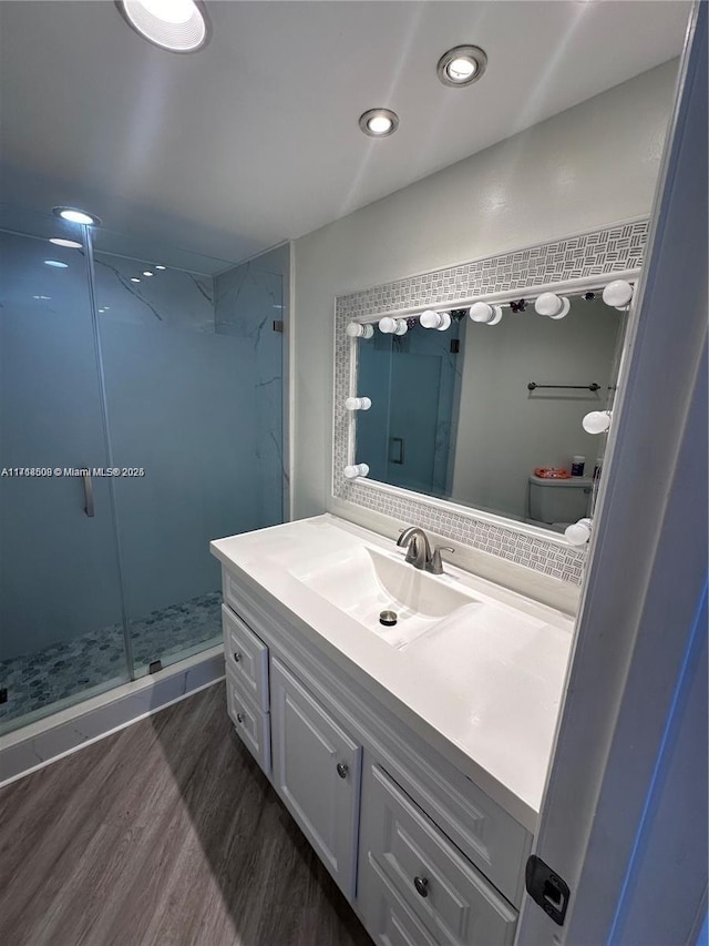 bathroom with walk in shower, vanity, and hardwood / wood-style flooring