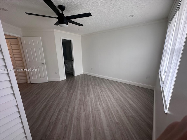 unfurnished bedroom with dark hardwood / wood-style flooring, ensuite bathroom, a textured ceiling, ceiling fan, and crown molding