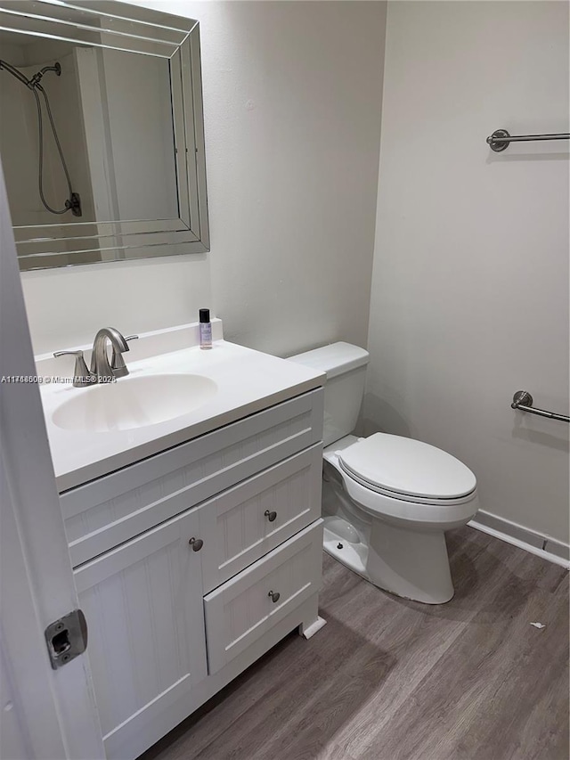 bathroom featuring hardwood / wood-style floors, vanity, and toilet