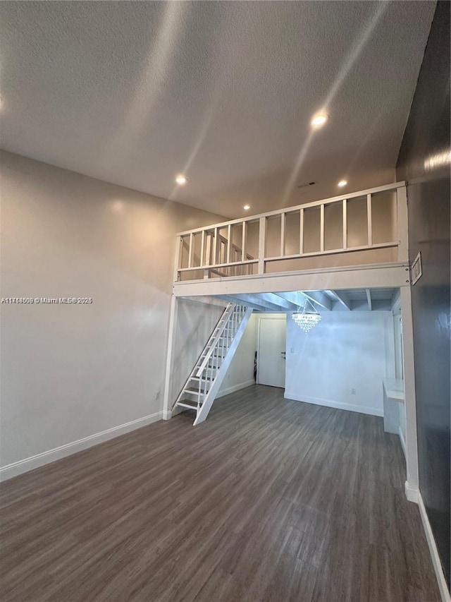 basement featuring a textured ceiling and dark wood-type flooring