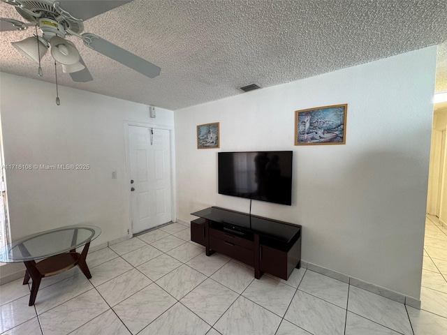 living room featuring a textured ceiling and ceiling fan