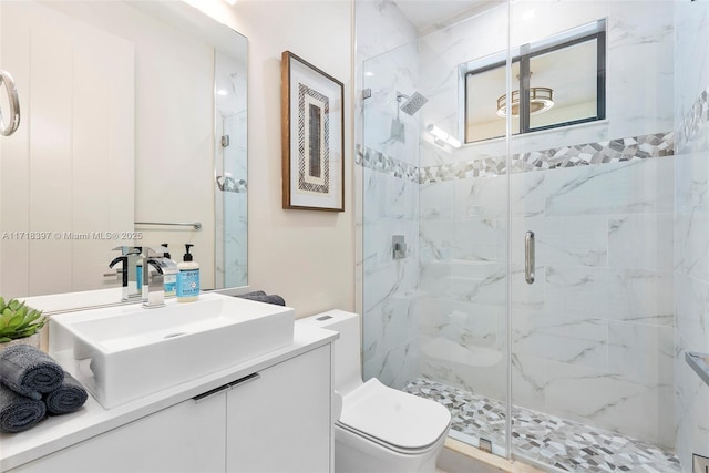 bathroom featuring vanity, toilet, and a shower with shower door