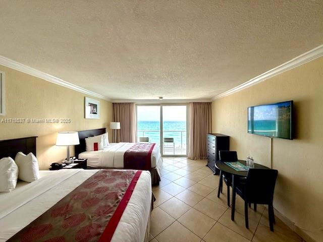 bedroom with a textured ceiling, ornamental molding, light tile patterned flooring, and access to outside